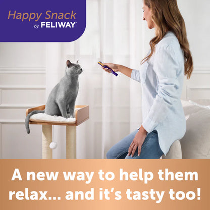 Woman using a device with a cat on a perch, promoting 'Happy Snack by FELIWAY'.